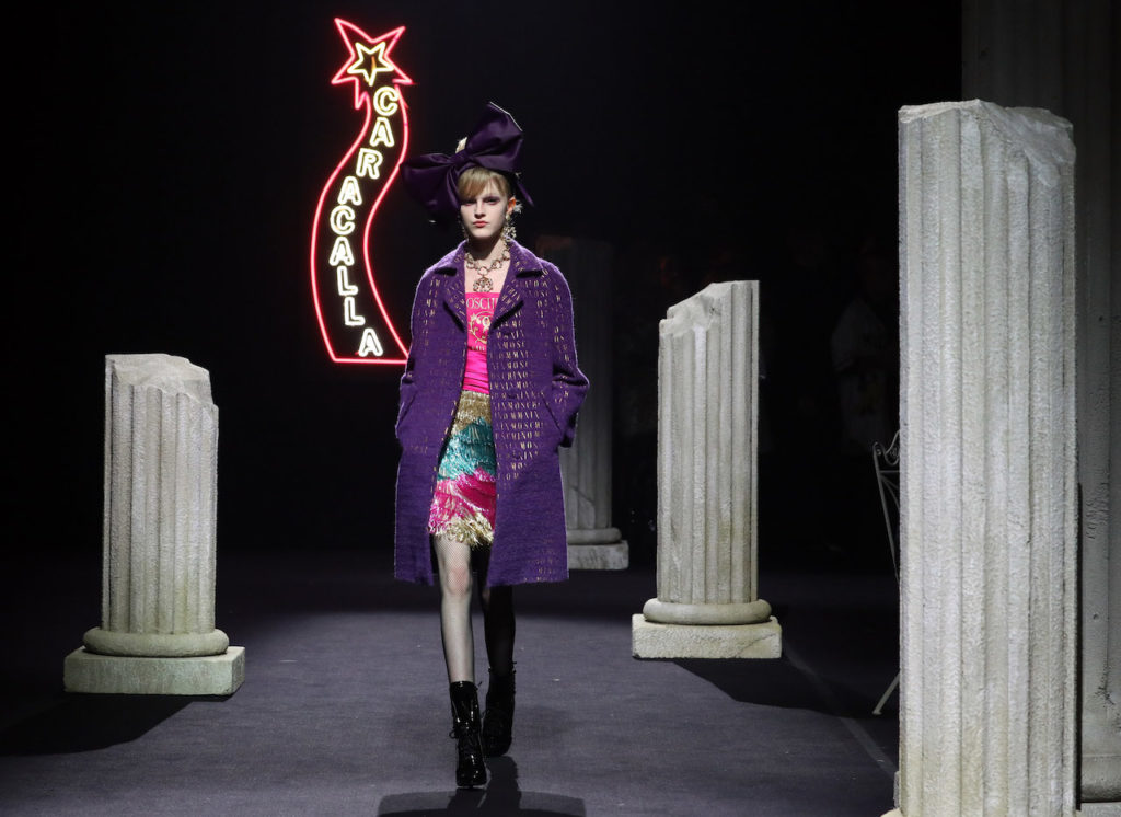 Una modella in cappotto viola sfila per Moschino